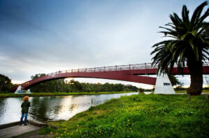 Red bridge over Maribrynong River with child in foreground